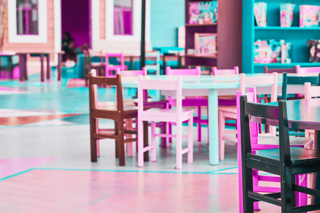 Salle de classe flexible colorée rose et bleue avec des meubles contenant du matériel pédagogique à disposition. Elle montre à quel point une classe flexible à pédagogie alternative est vivante